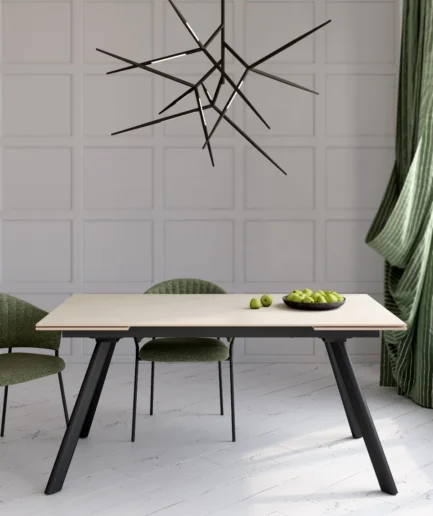 Mesa extensible Tasman con tablero porcelánico color arena y patas metálicas negras, abierta hasta 240 cm en comedor moderno.