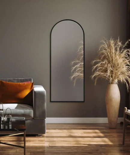 Espejo de pared con forma de arco y marco de aluminio negro, diseño minimalista para vestidor, salón o entrada.