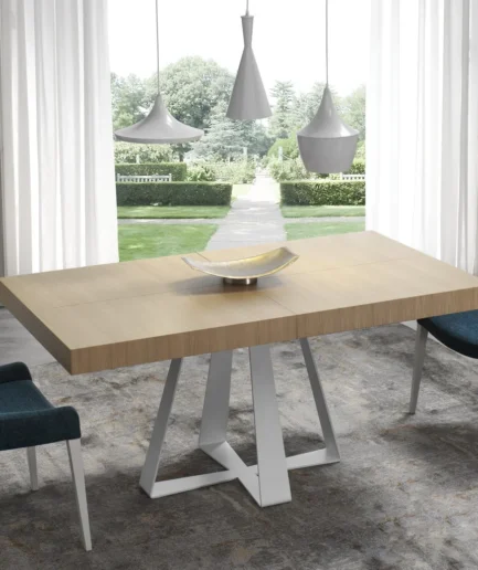 Mesa de salón extensible con tapa porcelánica, madera o cristal y estructura metálica lacada, disponible en diferentes tamaños y colores.