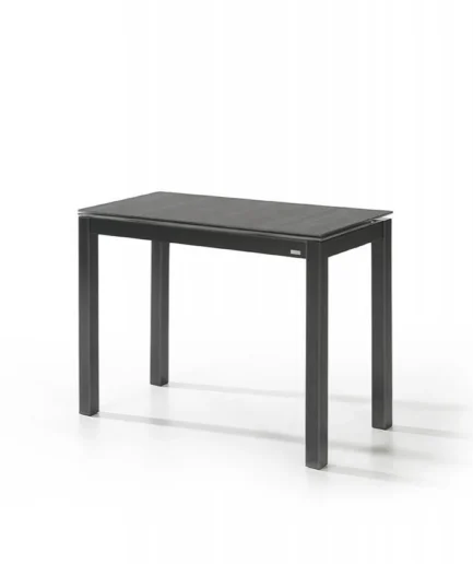 Mesa extensible Serie Lugano con chasis de acero pintado en epoxi, patas metálicas o de madera de haya y fresno, y encimera disponible en piedra sinterizada o cristal templado. Sistema de apertura frontal con guías telescópicas y extensible integrado de 30 cm.