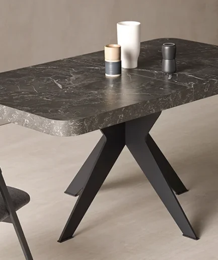 Mesa de comedor extensible modelo MON de PEMI con sobre grueso, pata metálica central y opción de acabados en madera, melamina o piedra.