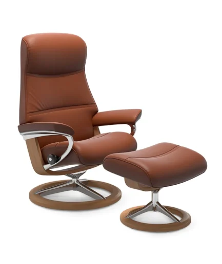 Sillón Stressless® Philip de respaldo alto y diseño envolvente, acompañado de reposapiés y disponible con bases Signature o Cross.